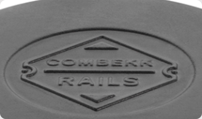 In reliëf aangebracht COMBEKK RAILS-logo op een gietijzeren oppervlak uit de Original Collection.